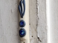 A close-up view of the mezuzah on the doorpost to the right of the front door. The mezuzah appears to be in the hinge area of what may have been an older door.