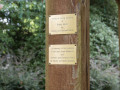 A close-up view of the memorial marker for Bobby Shore and the memorial marker for Louis and Anna Schwartz and Herbert and Florence Freed on the right, front post of the sukkah.