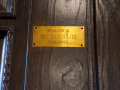 A close-up view of the plaque on the inside of the front doors of the synagogue.