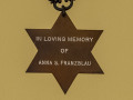 A close-up view of the Star of David memorial attached to the bottom of the eternal flame.