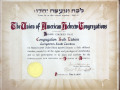 A close-up view of a framed certificate from the Union of American Hebrew Congregations, on the wall in the small office.