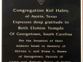 A close-up view of a plaque on the wall in the small office.