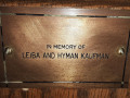 A close-up view of the plaque on the fourth pew from the front on the left side of the sanctuary.