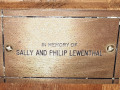 A close-up view of the plaque on the nineth pew from the front on the left side of the sanctuary.