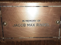 A close-up view of the plaque on the second pew from the front, on the right side of the sanctuary.