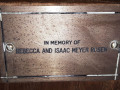 A close-up view of the plaque on the third pew from the front, on the right side of the sanctuary.