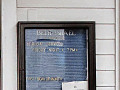 A close-up view of the enclosed message board on the right side of the front door of the synagogue. The small plaque in the bottom, left hand corner of the message board reads, “In memory of Max and Bertha Lipsitz.
