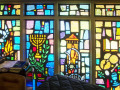 A closer, partial view of the stained-glass windows adjacent to the bema, on the far, right end of the right wall of the sanctuary.
