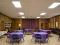 A view of the Social Hall, looking from the back of the room toward the front of the room.