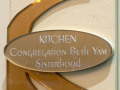 A close-up view of the acrylic plaque on the wall to the left of the kitchen door.