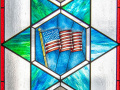 A close-up view of the first stained-glass window on the left side of the sanctuary.