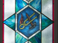 A close-up view of the third stained-glass window on the left side of the sanctuary.