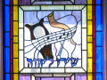 “Sing to the Lord” stained glass window and plaque, right side of sanctuary, 1st window from the back.