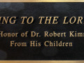 “Sing to the Lord” stained glass window and plaque, right side of sanctuary, 1st window from the back.