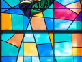 A close-up, full length view of the stained-glass window on the front wall of the sanctuary, to the right of the ark.