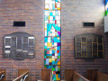 A view of the first, full-length stained-glass window from the right, on the far, right end of the right wall of the sanctuary.