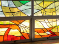 A close-up view of the memorial panes on the first and second panels (from left to right) of the stained-glass windows in the social hall.