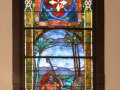 A close-up view of the first stained glass window, closest to the bema, on the left wall of the sanctuary.