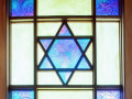 A close-up view of the stained-glass window above the front doors of the synagogue.