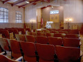 A view of the sanctuary, looking from the right, back corner of the room toward the left, front corner room, showing the ark and part of the bema.