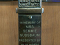A close-up view of the plaque on the standing menorah to the left of the bema.