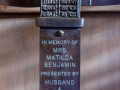 A close-up view of the plaque on the standing menorah to the right of the bema.