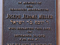 A close-up view of the right plaque above the marble-topped table in the lobby of the synagogue.